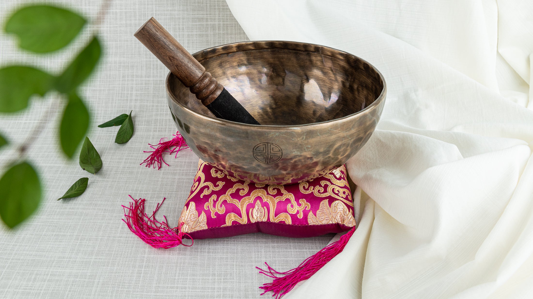 Singing bowl with cushion and mallet on white background