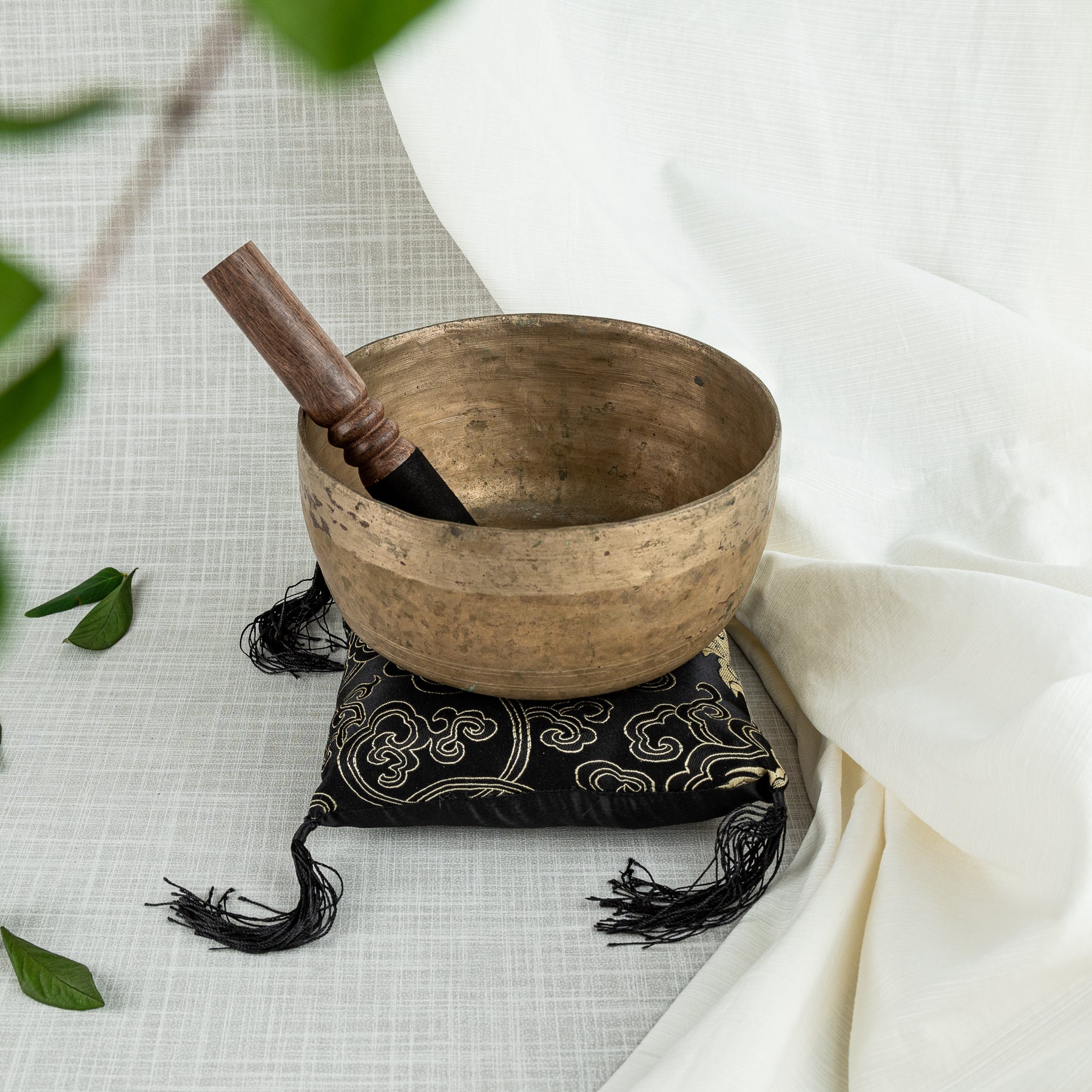 Antique singing bowl with mallet and pillow