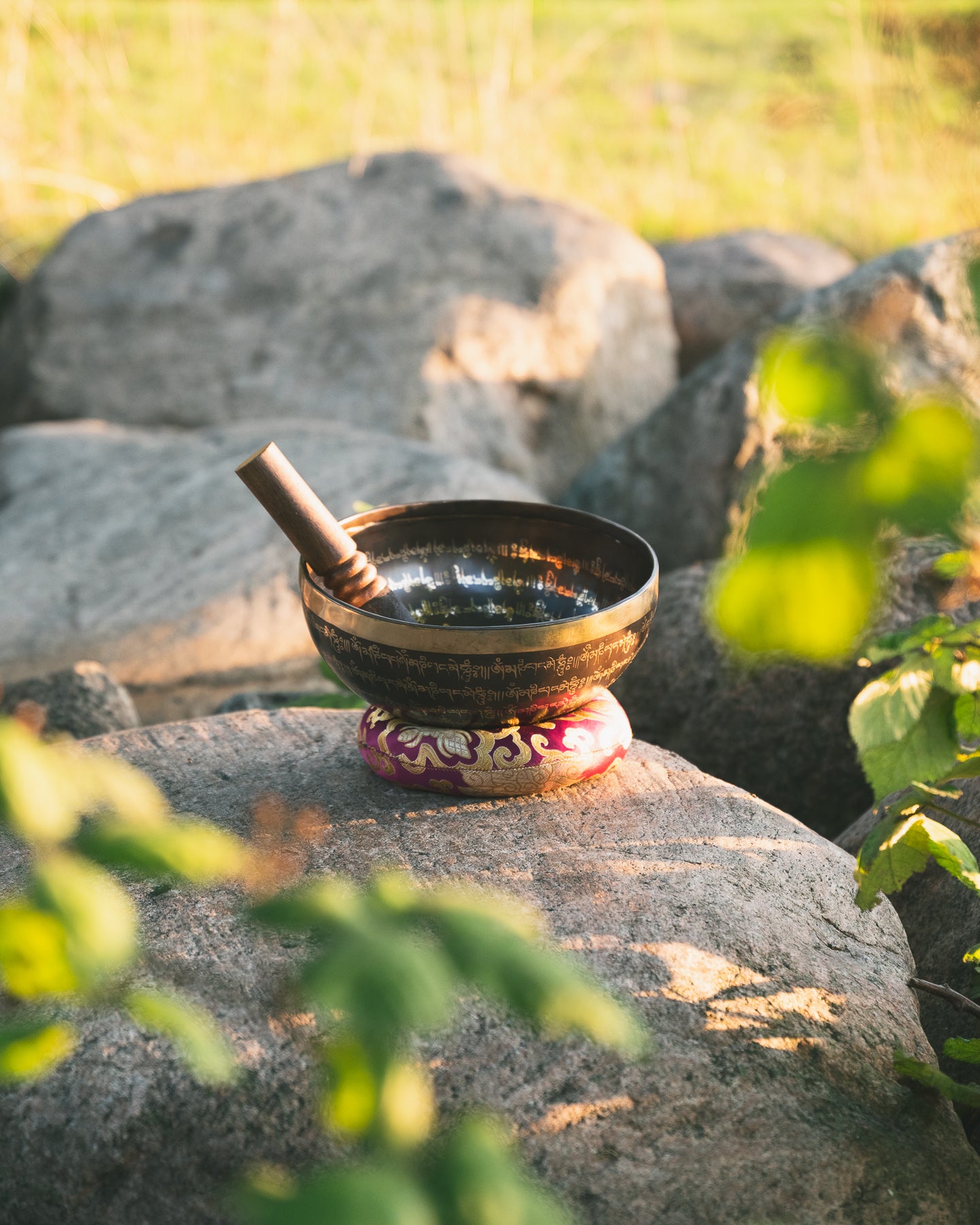 Singing bowl with mallet and pillow in nature